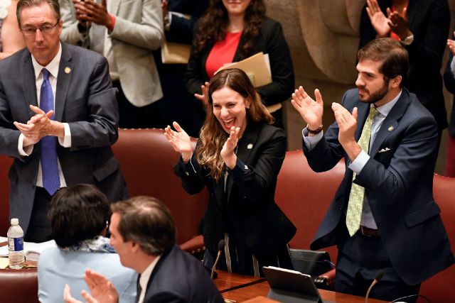 New York Senator Alessandra Biaggi, D-Bronx, center, celebrates after her legislation to change state legal standards on sexual harassment passed in June